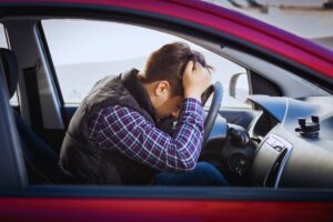 uomo disperato in auto